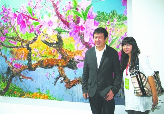 成都双年展艺术展现场，周春芽正站在自己的参展作品《彼岸桃花》前。 摄影记者 郭广宇