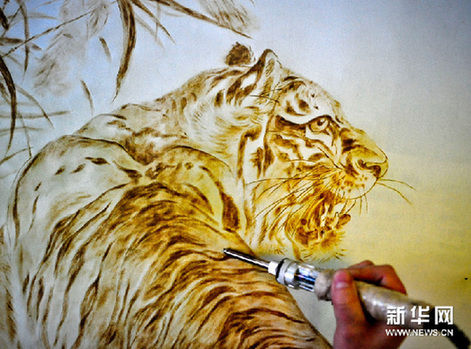 付玉在宣紙上用烙鐵繪出一隻活靈活現的老虎（2月22日攝）。新華網圖片 張超群 攝