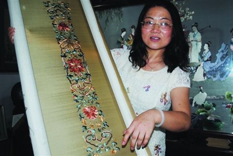 陈英华向记者展示又一幅刚完成的“宁寿宫花园符望阁双面绣夹纱”。  周建越  摄