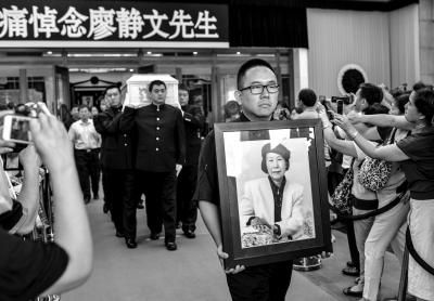 6月20日上午，亲人手捧先生的遗像走出。京华时报记者王苡萱摄