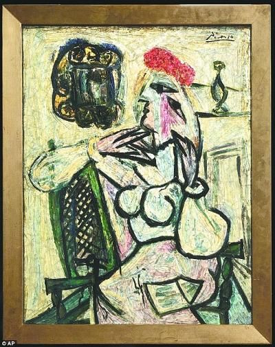 右图为毕加索真迹《戴红帽子的坐着的女人》。