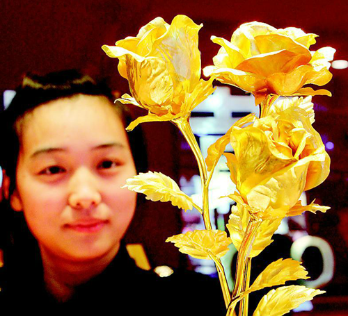 2月9日，江苏连云港市赣榆县一家金店的营业员在展示“黄金玫瑰”。