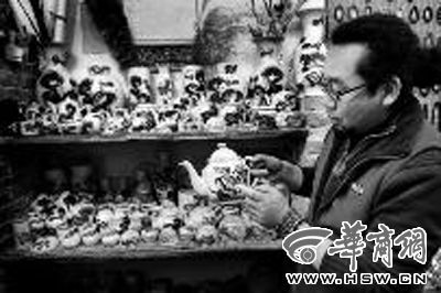 昨日下午，吴宏勃介绍手中这件茶壶“太师少保”的贴花工艺 本报记者 赵彬 摄
