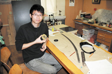 张弓野手拿一把日本武士刀的刀柄精心研究，进行修复前的准备。（长沙晚报 张弓野 提供）