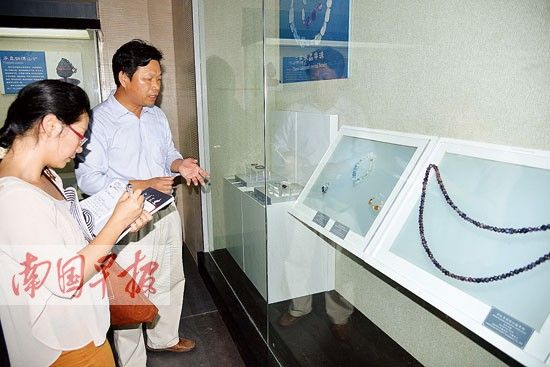 合浦汉代文化博物馆馆长廉世明在介绍馆藏的绿柱石饰品。