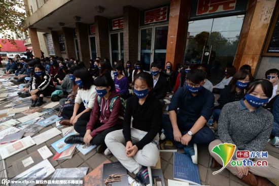 2014年11月23日，戴口罩的艺术家们在上海东昌电影院门口静坐，希望让中国当代艺术“静一静”