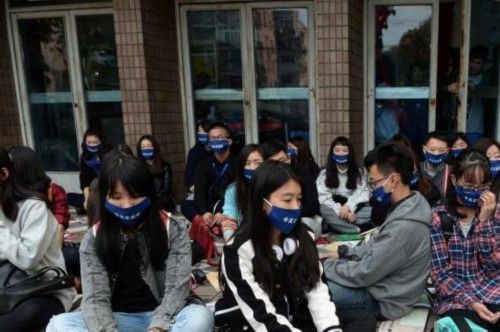 2014年11月23日，戴口罩的艺术家们在上海东昌电影院门口静坐，希望让中国当代艺术“静一静”