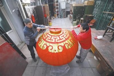 　2月17日，北京市美术红灯厂翟玉良经理(左一)和工人展示直径1.5米的大红灯笼。本版采写/新京报记者 王贵彬 摄