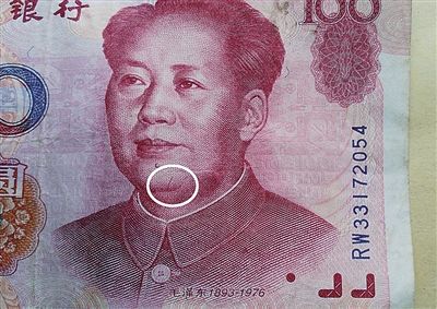 99年版百元大钞头像右边痣下方，有一条3毫米的红色竖曲线（白圈处）。