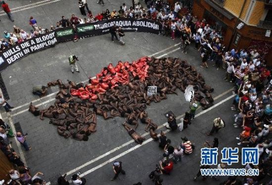 身上涂有颜料的动物保护主义者躺在地上组成一头流血的公牛的图案，呼吁废除斗牛和奔牛活动