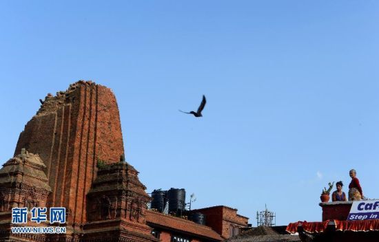 5月3日，两名尼泊尔妇女眺望巴德岗杜巴广场湿婆神庙，该神庙顶部坍塌。