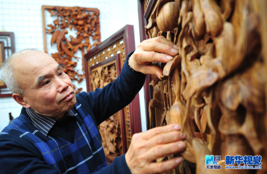 王樹元介紹自己的木雕作品。