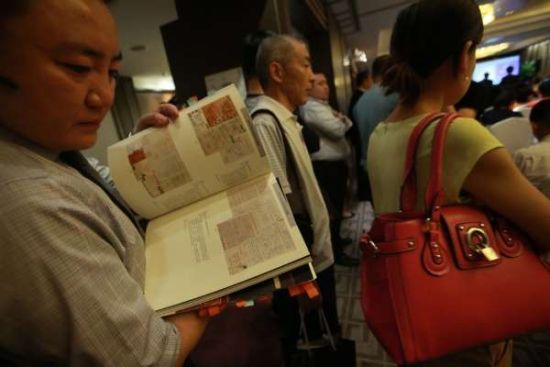 6月3日，北京一位参拍者正翻阅拍卖目录里的钱钟书书信手稿影音页。