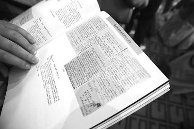 2013年6月3日，一位参拍者正翻阅拍卖目录里的钱钟书书信手稿影印页。吴海浪/CFP