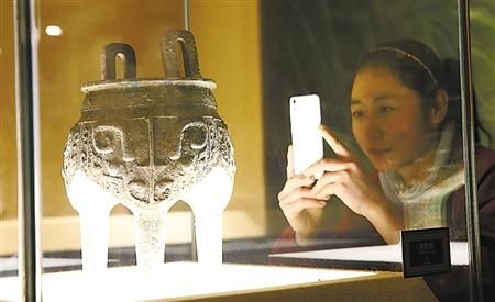 市民用手機拍攝博物館裡的火鍋藏品