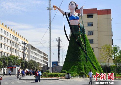 新疆乌鲁木齐市“飞天”造型绿色植物花堆，在网络与现实中都引起了热议。图为“飞天”正面全身照，她的“骨架”是由十几吨的钢材搭建。马新龙 摄 