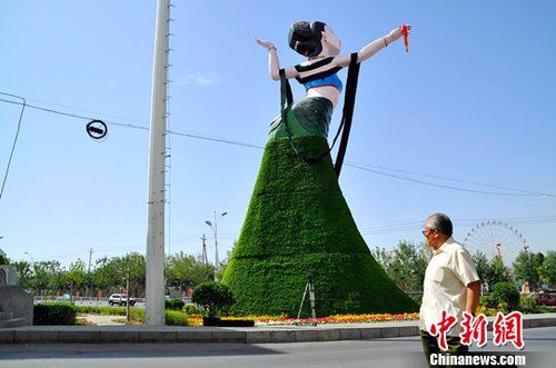 新疆乌鲁木齐市“飞天”造型绿色植物花堆，在网络与现实中都引起了热议。图为“飞天”的背面，背面的热议焦点是：“臀部太大了，与人物整体很不协调。”马新龙 摄