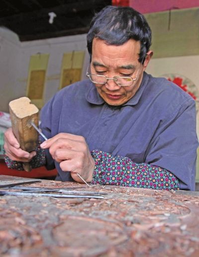 陈景知在雕刻木版年画模板