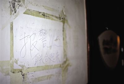 昨日，鸿凌阁收藏公司门口墙壁上留有受骗者写的“报警，联合起来”字样。新京报记者 周岗峰 摄