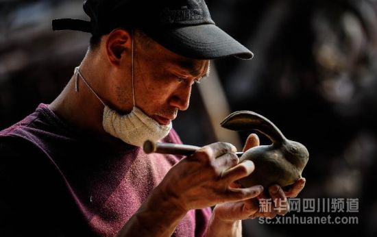 4月18日，工艺师在芦山县天功根意金丝楠乌木艺术馆里制作乌木根雕作品。