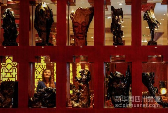 4月18日，一名顾客在芦山县良友木缘根雕艺术馆里参观。