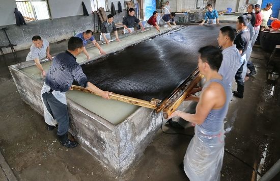 安徽省涇縣紙工製作巨型紙“三丈特宣”撈紙的現場，此道工序需要十多位工人協調配合才可進行謝震霖圖