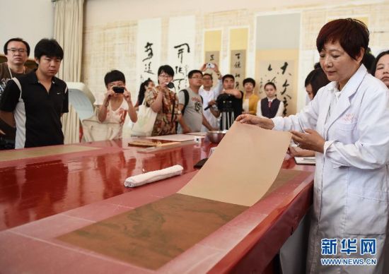 5月27日，首都博物馆书画装裱专家楼朋竹在展示利用生物揭展剂把一幅古书画的背纸轻松完整揭离。