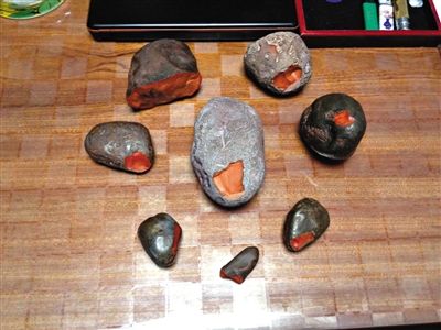 收藏者鲁玉苗展示8块南红玛瑙石，最小的拇指大小的那块，估价为1.8万元。