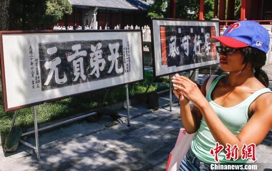 27日，中国古代匾额科举拓片展在北京国子监开展，牌匾与古殿共同述说着历史变迁的荣辱兴衰，见证千年的科举文化。图为游客参观拓片展。 张浩 摄