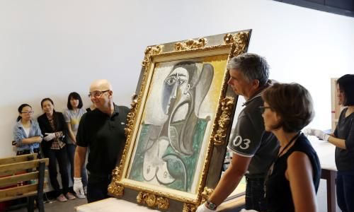 工作人员展示刚刚开箱的毕加索作品《坐着的女人半身像》。