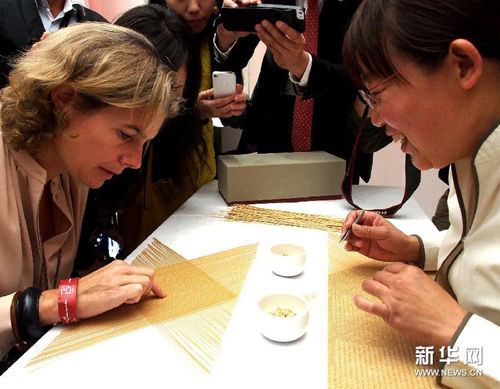 （2）10月19日，参观者在观赏中国手工艺师现场制作的竹子手工艺品。