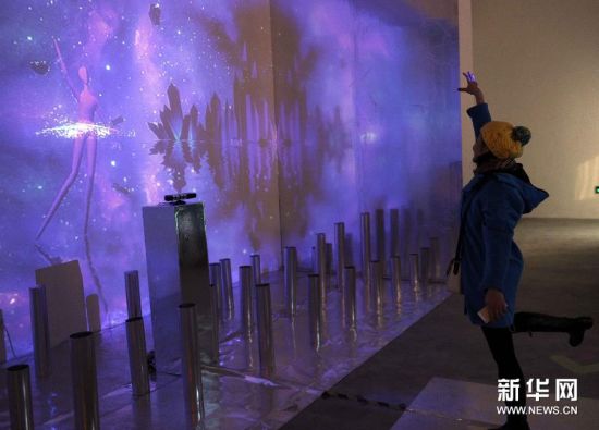 11月18日，一名参观者在体验互动作品《天鹅湖》。