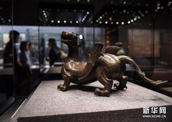 6月23日，观众在首都博物馆欣赏由河北省文物研究所收藏的错银铜双翼神兽。